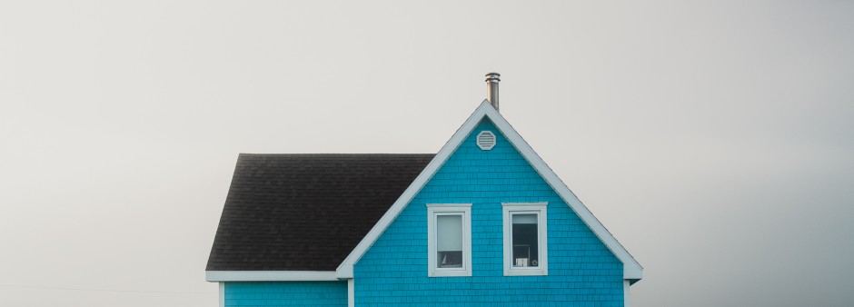 Maison traditionnelle des Îles, de couleur bleue, avec un décor arrière perdu dans la brume